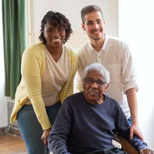 man sitting down with friends behind