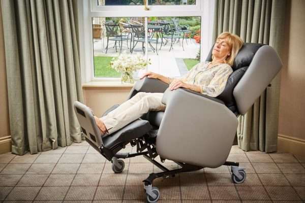 lady reclined in Lento care chair. indoors.