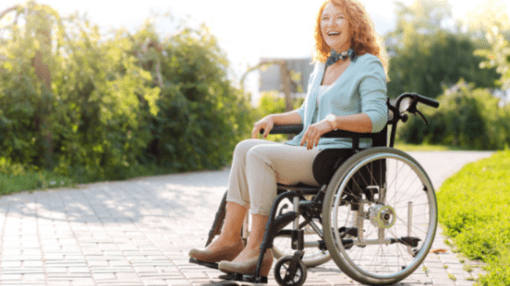 Woman sitting on a wheelchair. Outdoors.
