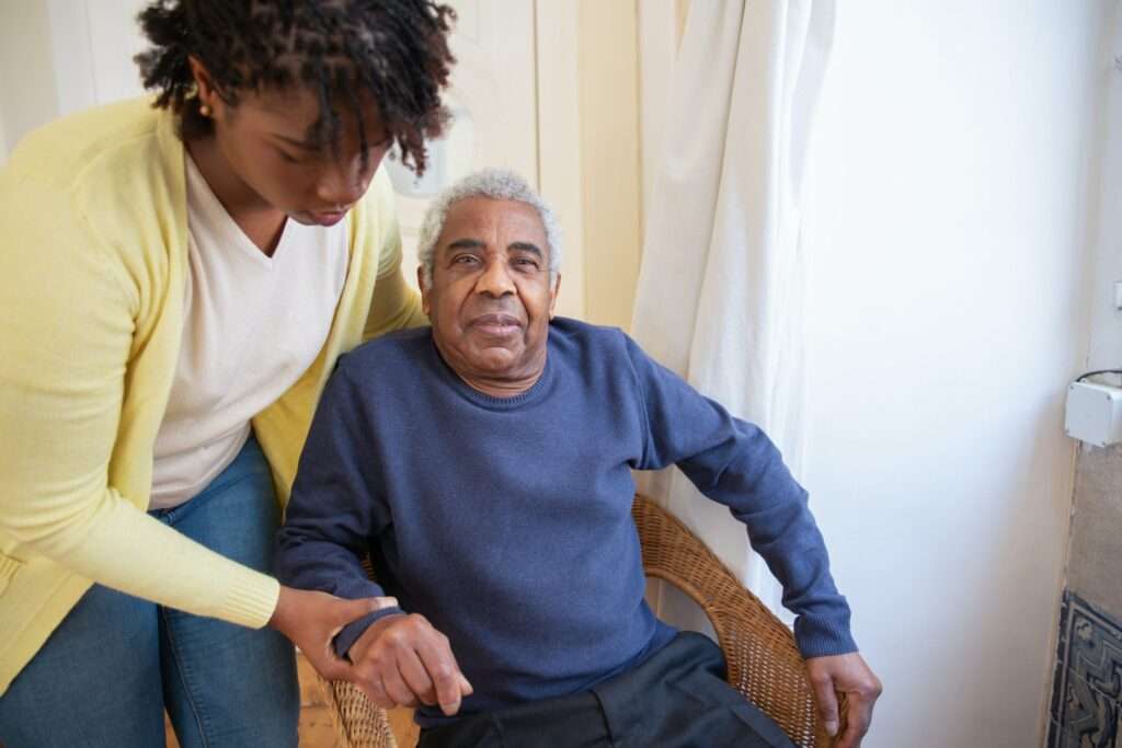 woman assisting man in chair