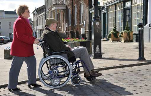 lady pushing man in wheelchair
