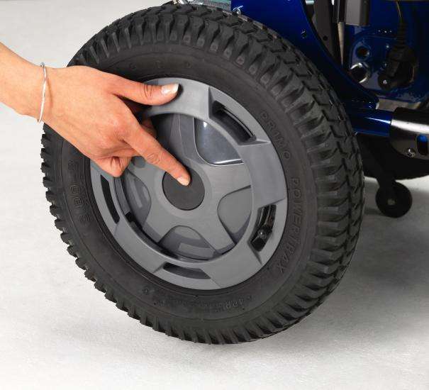 Close up of the Esprit power wheelchair rear wheel. A woman is pressing the centre button on the wheel.