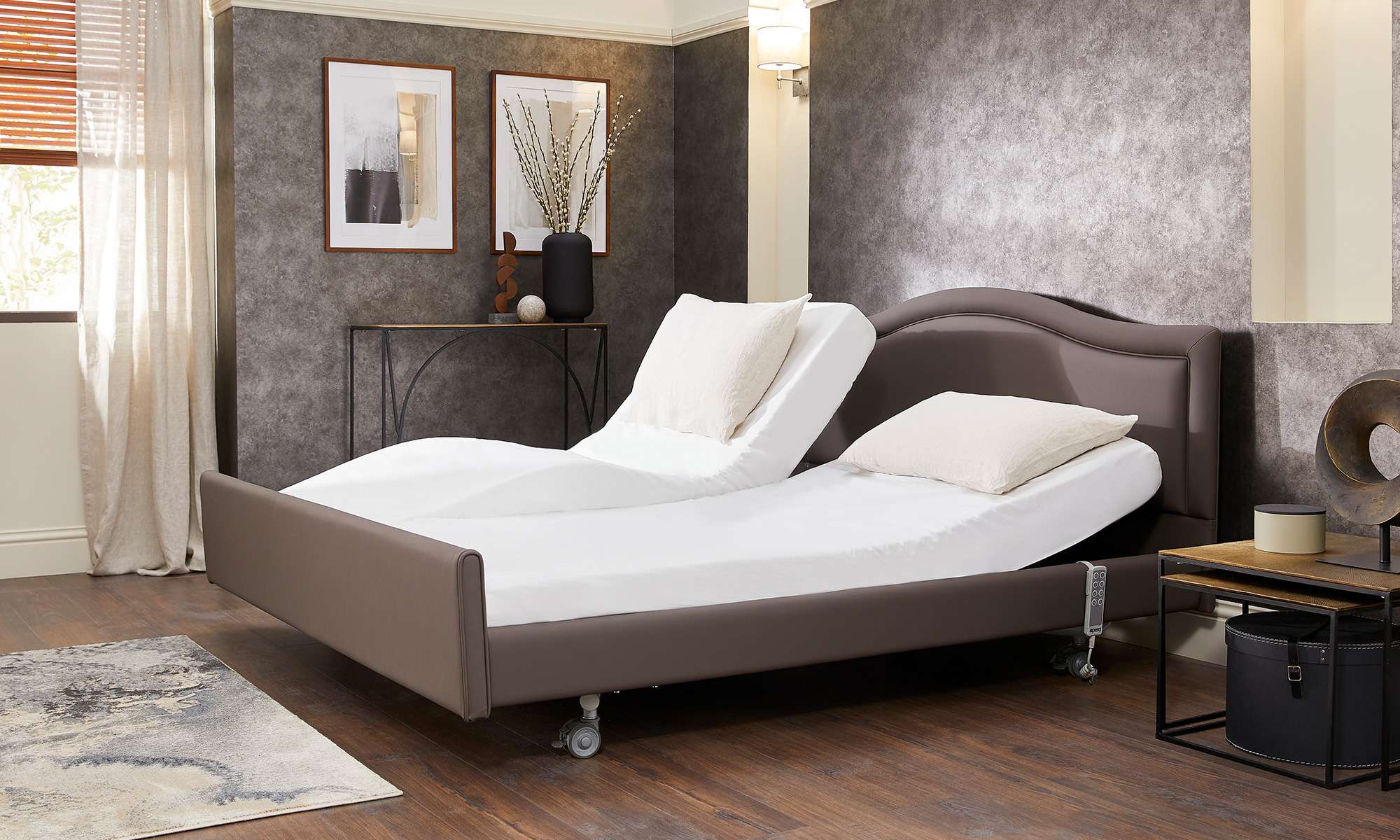 Lifestyle shot of a double electric adjustable bed with one mattresses profiling. The picture is in a bedroom with a single rug.