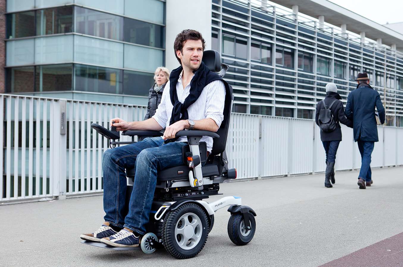 A man sat in an electric wheelchair on an inner city pavement