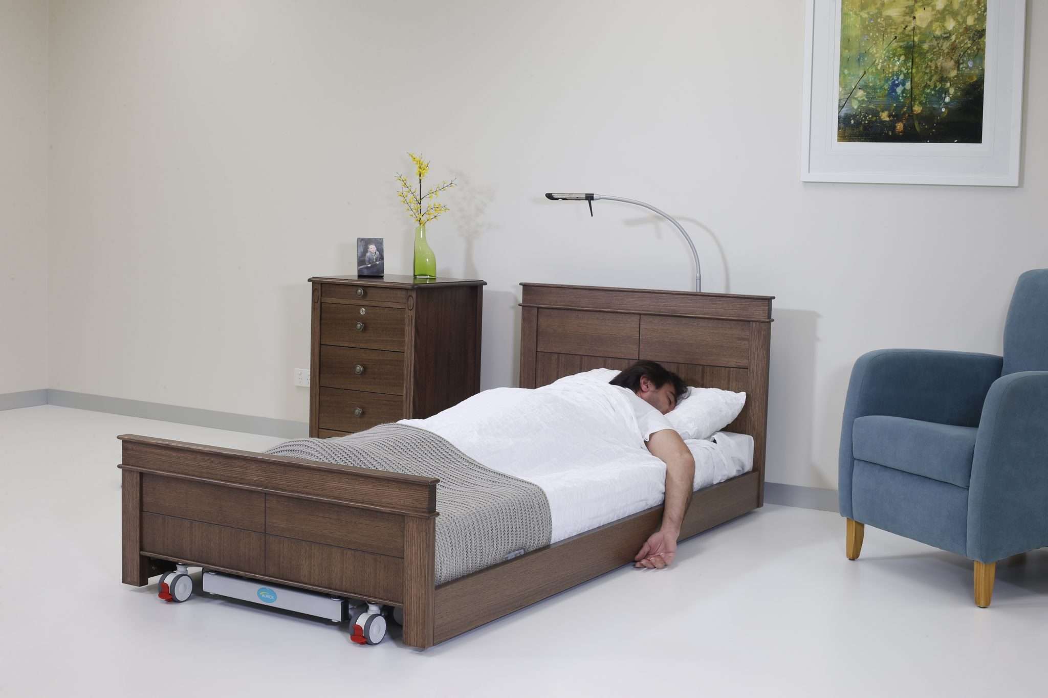 A man asleep in an ultralow bed that helps to prevent falling out of bed
