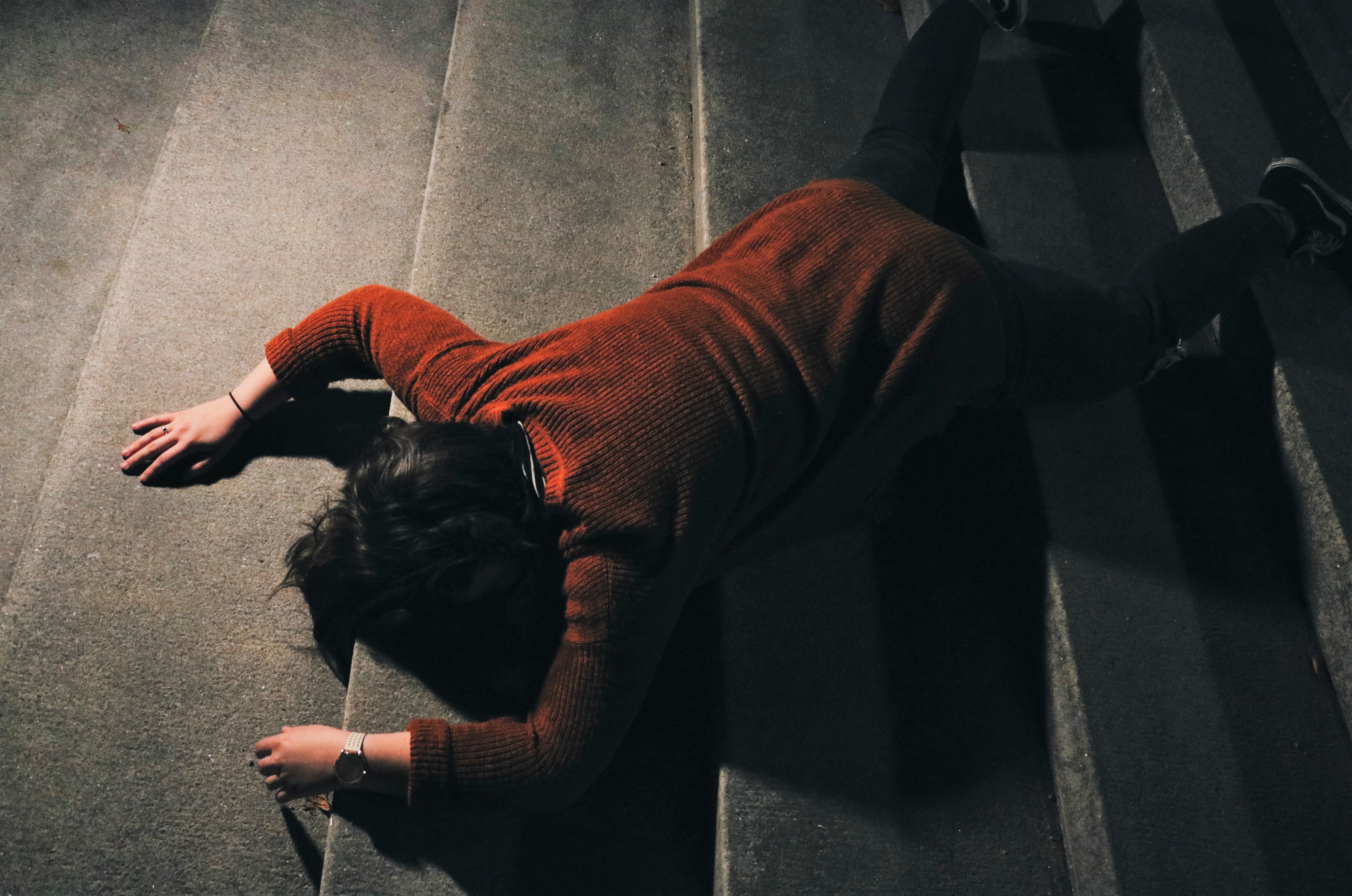 A woman fallen over on the floor face down.