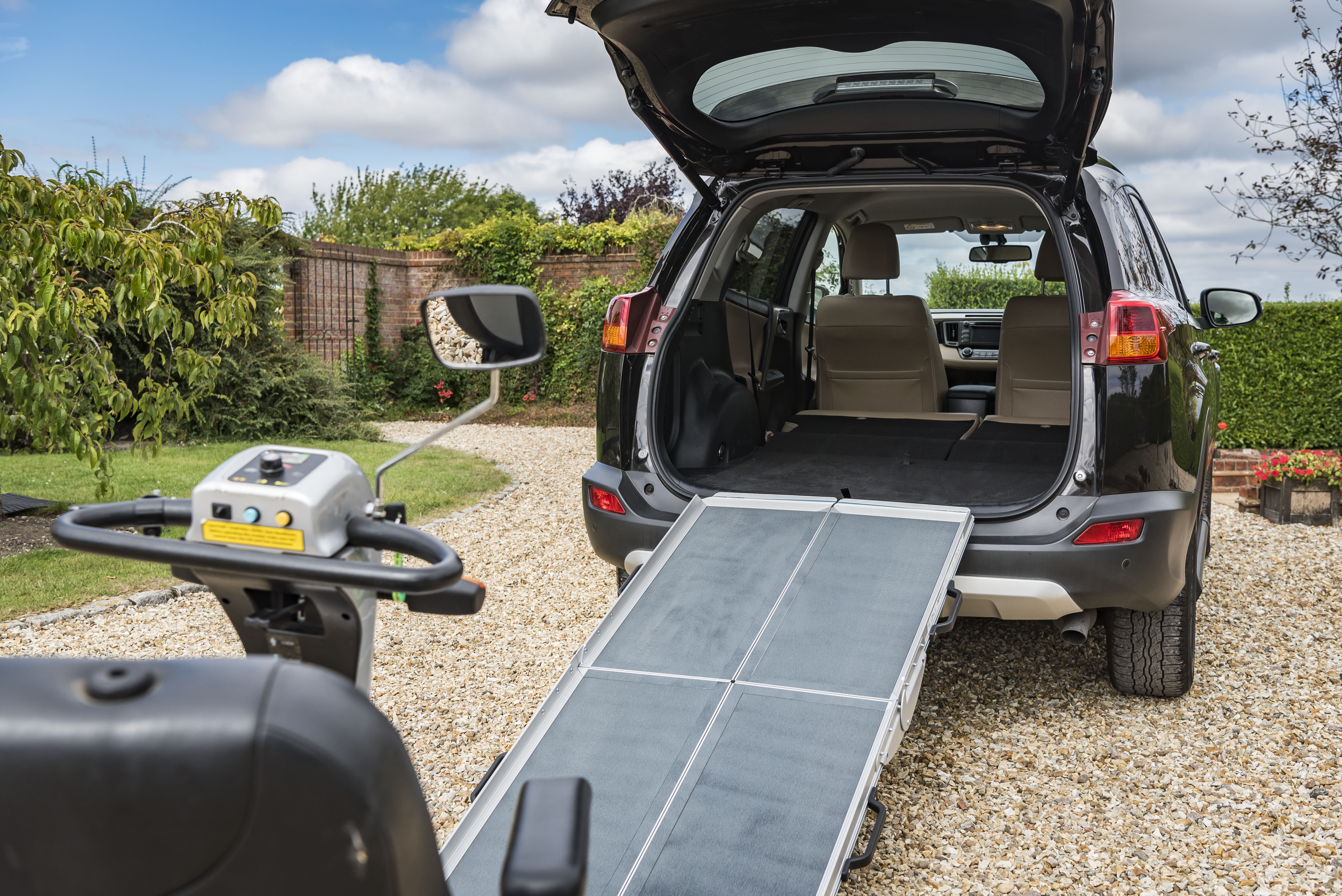 A foldaway ramp leading a mobility scooter up into the back of car