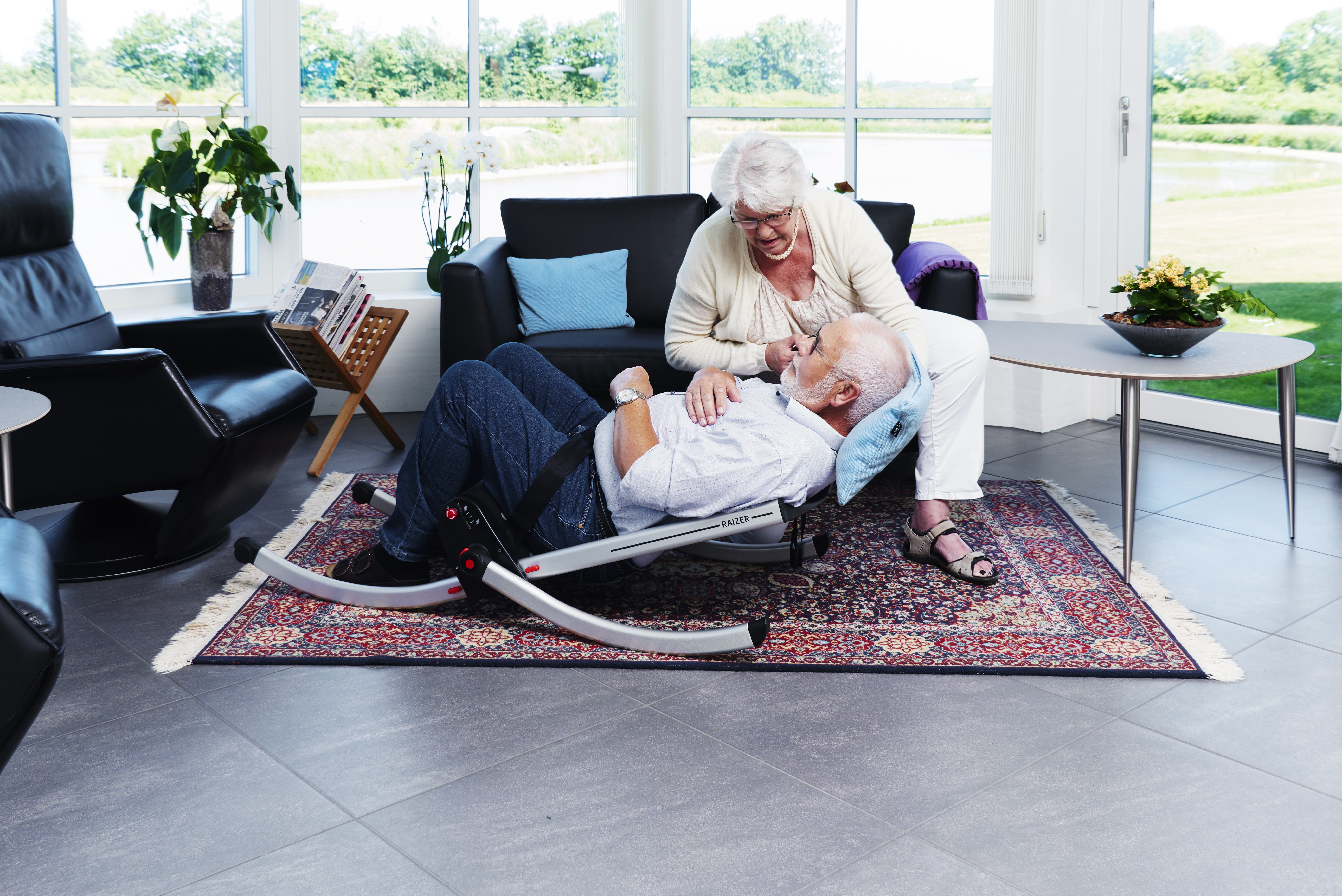 A man being lifted off the floor using the Raizer lifting chair.