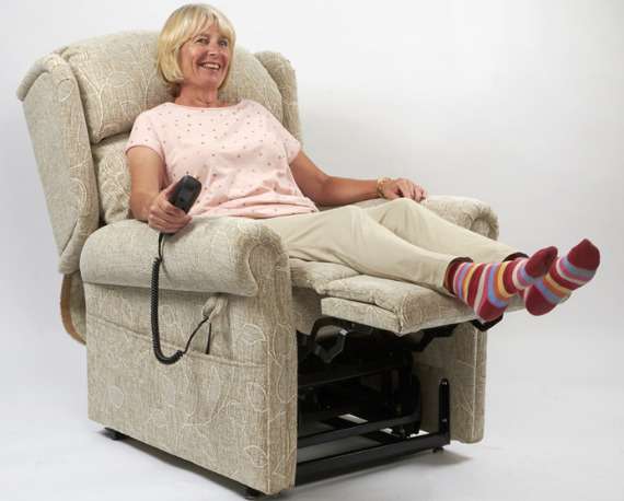 Elderly woman sitting in a mobility recliner chair with the footrest extended.