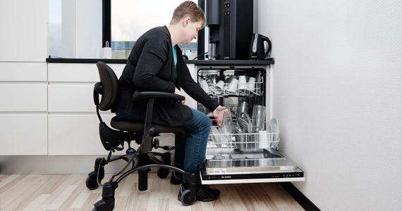 A Vela Activity Chair can be used to perform household chores - like loading the dishwasher