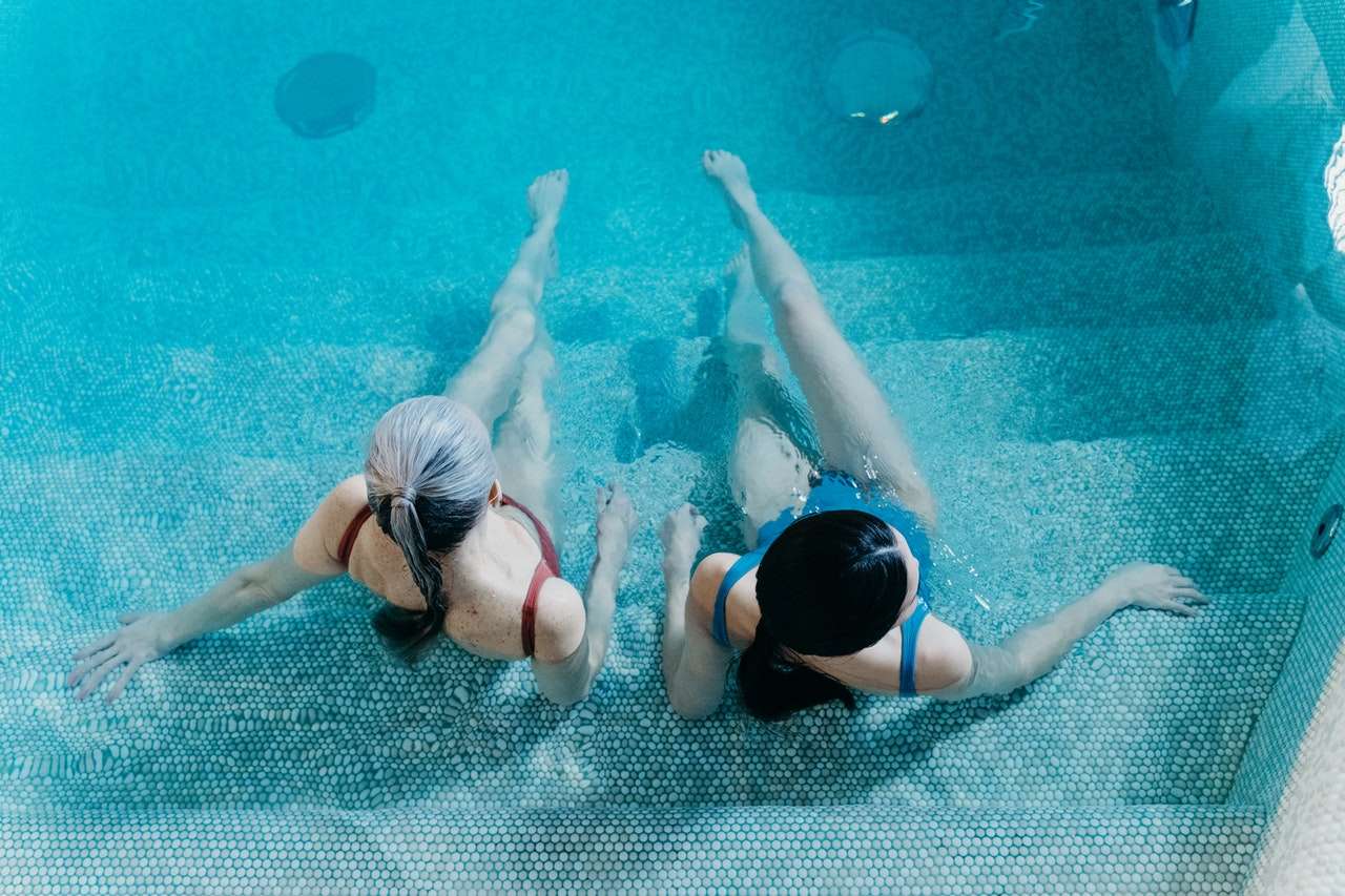 Two ladies exercising in a swimming pool.