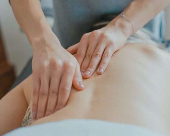 A woman receiving a physical exam along her spine.