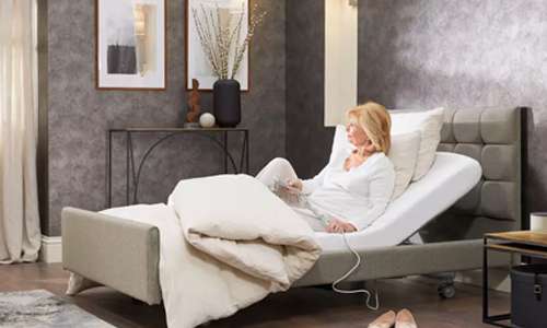 Elderly woman in an electric profiling recliner bed.