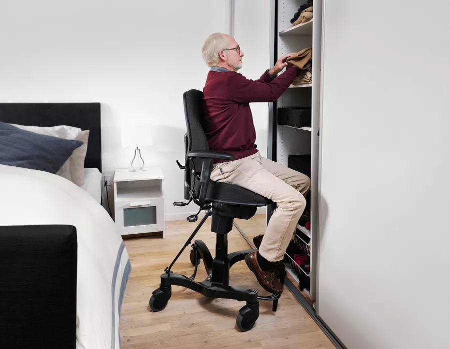 Elderly Man in Bedroom Using Electric Sit to Stand Chair Feature of the VELA 700e disability chair