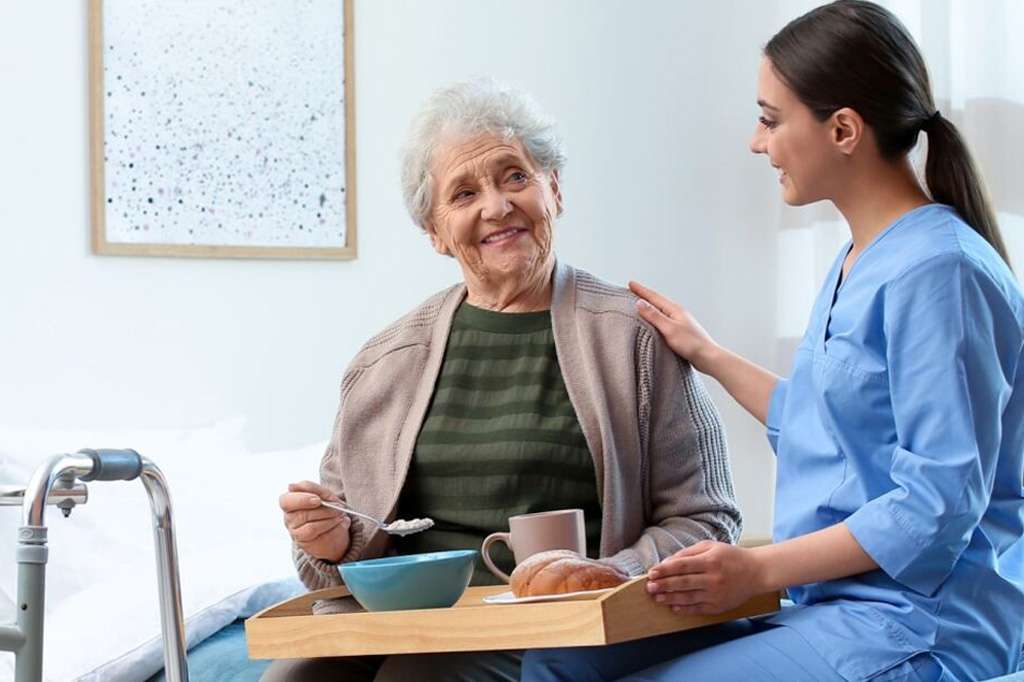 nurse sitting next to older lady