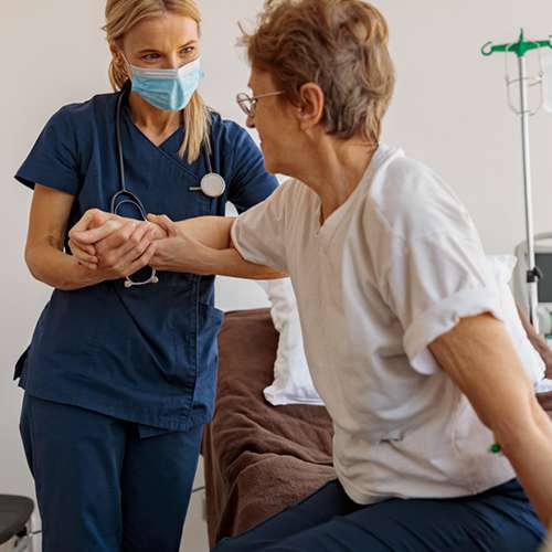 nurse helping woman stand