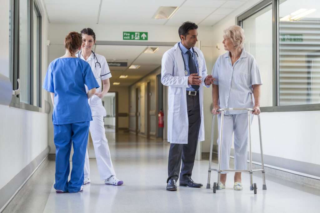 doctor, nurses and patients in hospital corridor