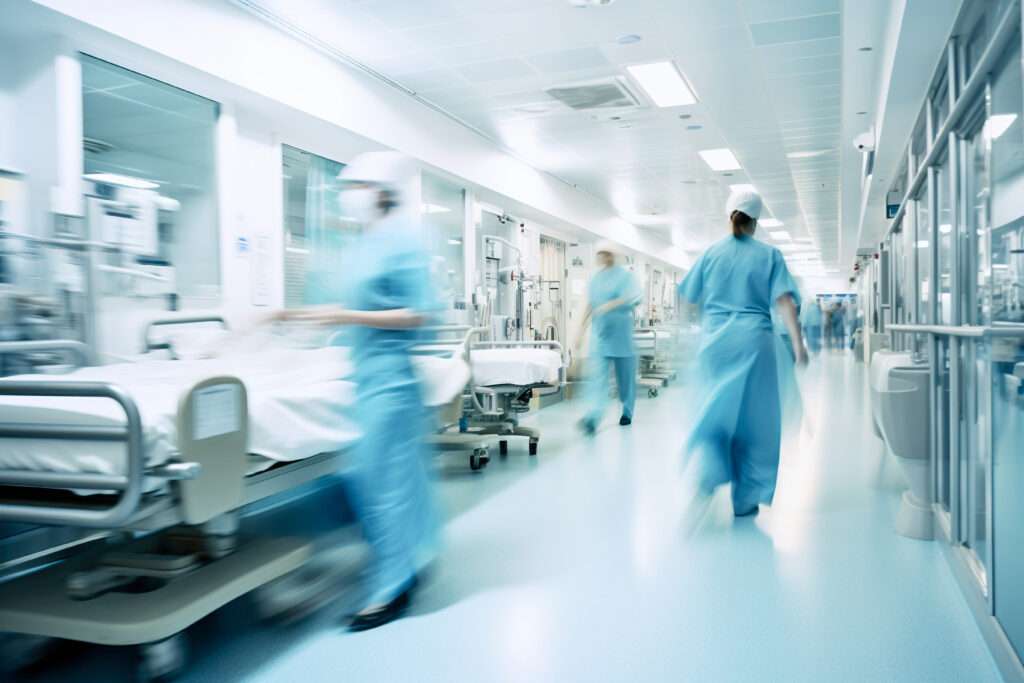 Long exposure blurred motion of medical doctors and nurses in a hospital ward wearing blue aprons, walking down a corridor - Generative AI