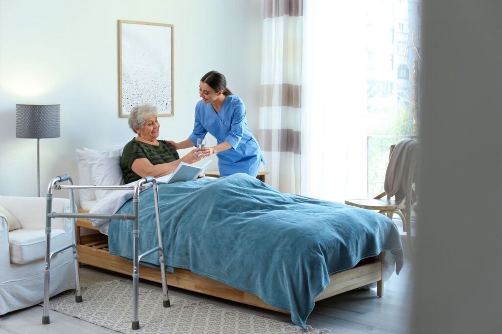 nurse helping patient in bed