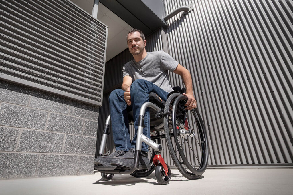 Man in a Quickie QS7 R wheelchair outside a modern building